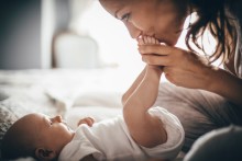 Mother kissing newborn baby's feet