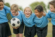 5 young soccer players laughing