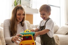 Mother and son playing with toy car