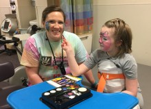 Occupational therapist and child face painting