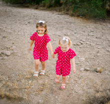 Two young girls holding hands outside