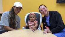 Mom, child, and occupational therapist sitting at table and smiling