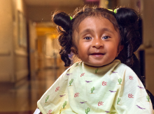 Little girl in hospital gown smiling