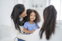 Smiling little girl with parent and provider