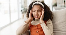Adolescent girl pressing her temples in pain