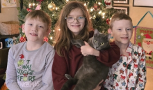 Siblings in front of holiday tree