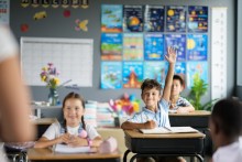 Child raising hand in classroom